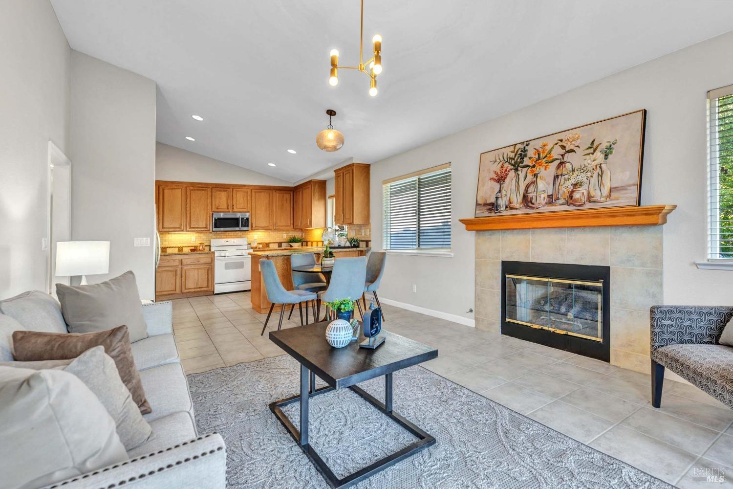 a living room with furniture a fireplace and kitchen view