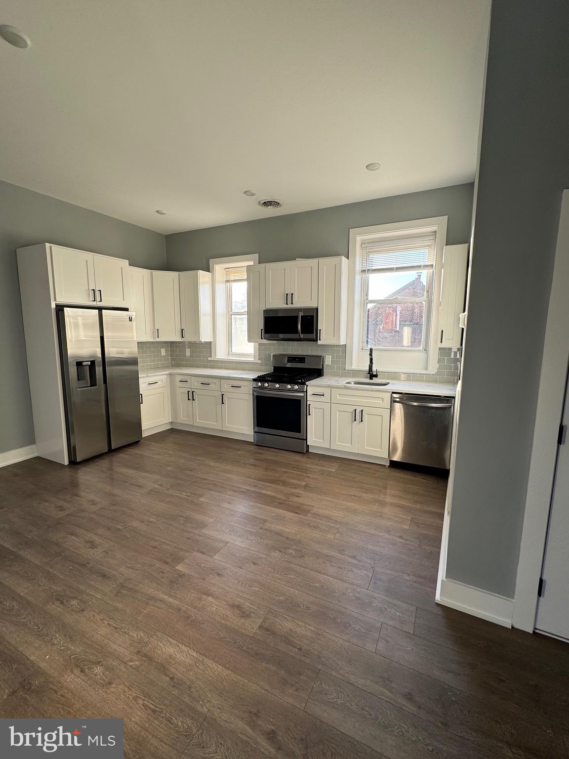 a large kitchen with a stove a sink and a refrigerator