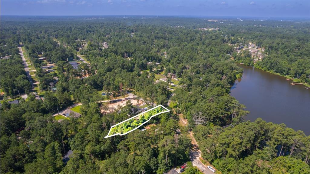 an aerial view of residential house with outdoor space and trees all around