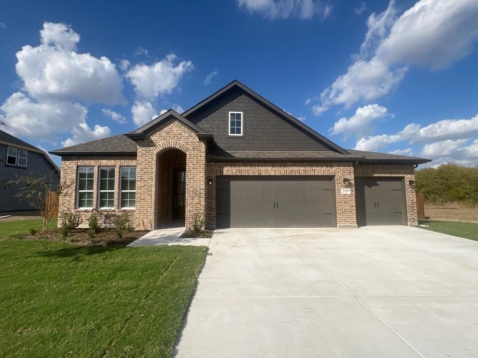 a front view of a house with a yard and garage