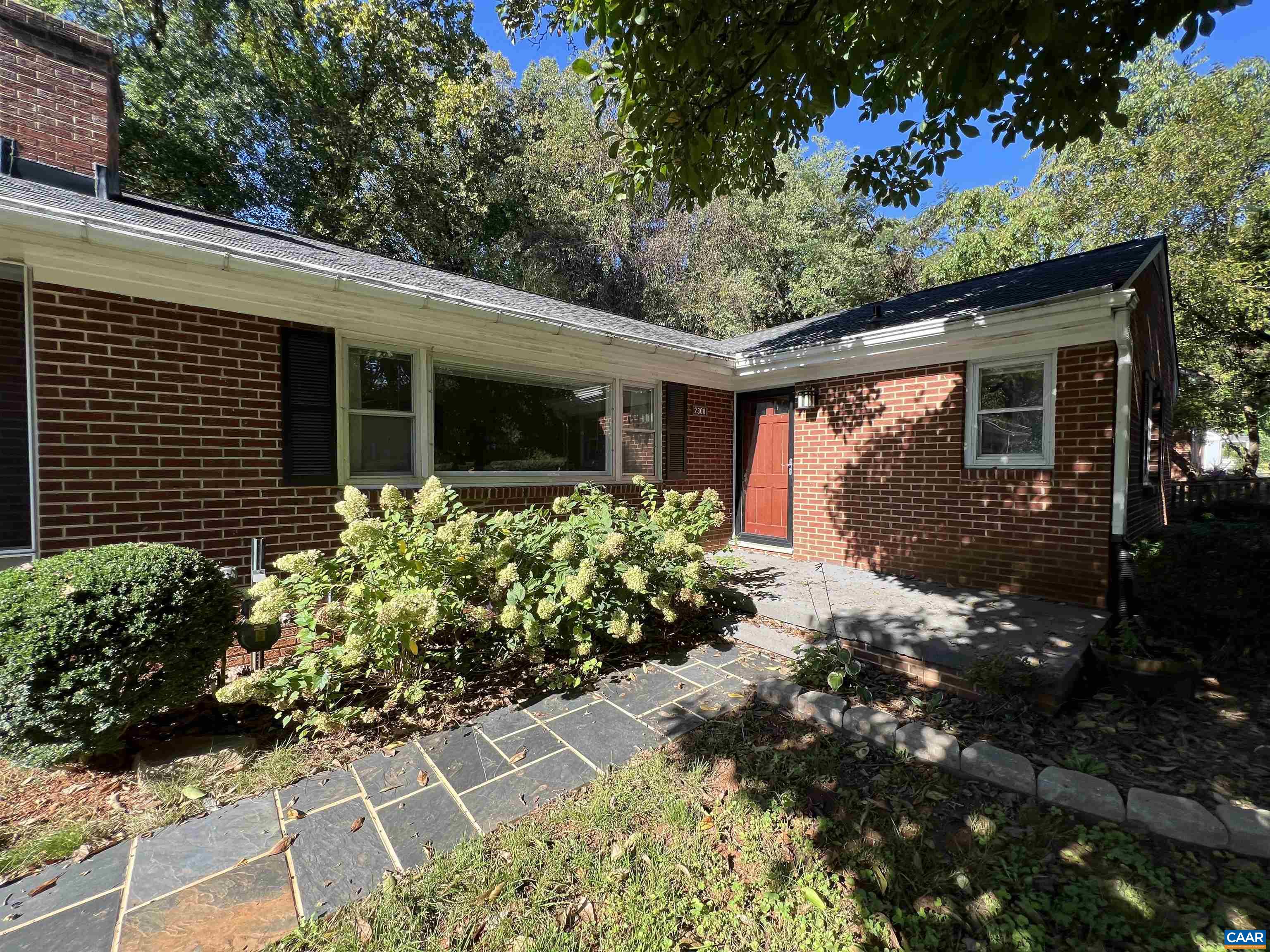 a front view of a house with a yard and potted plants