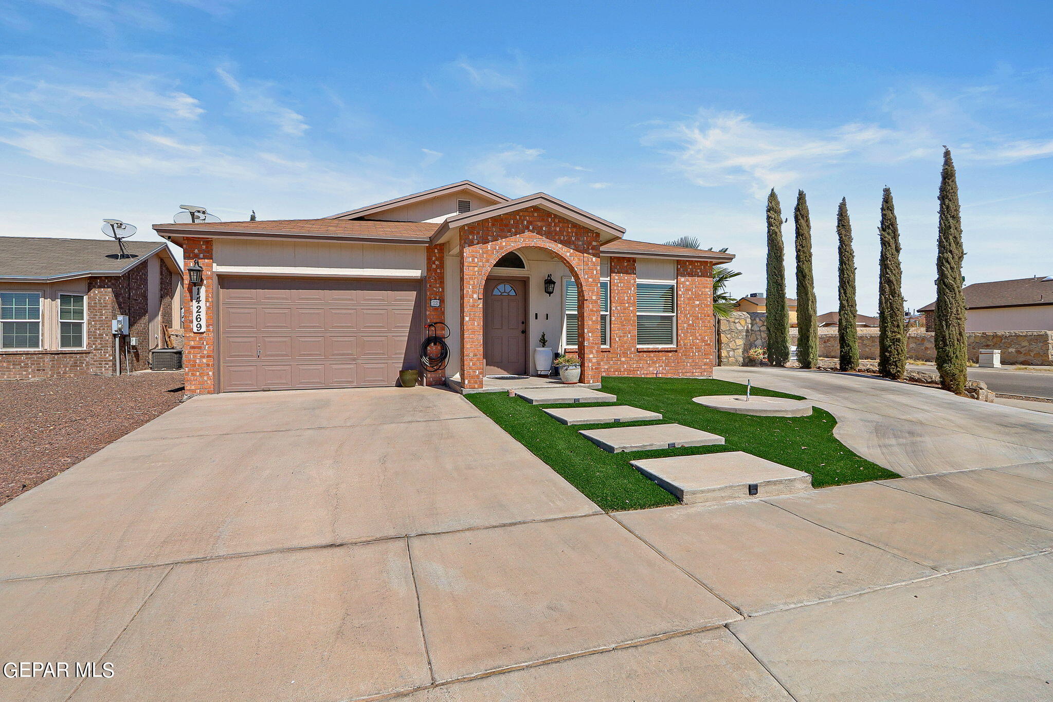 a front view of a house with a yard and trees