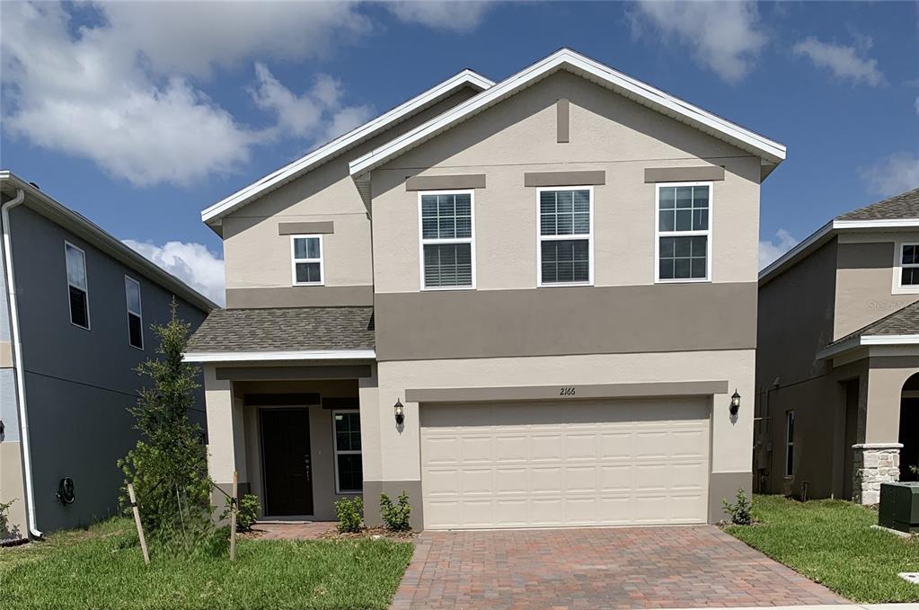 a front view of a house with a yard and garage