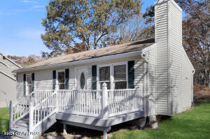 a view of a house with a yard and wooden deck