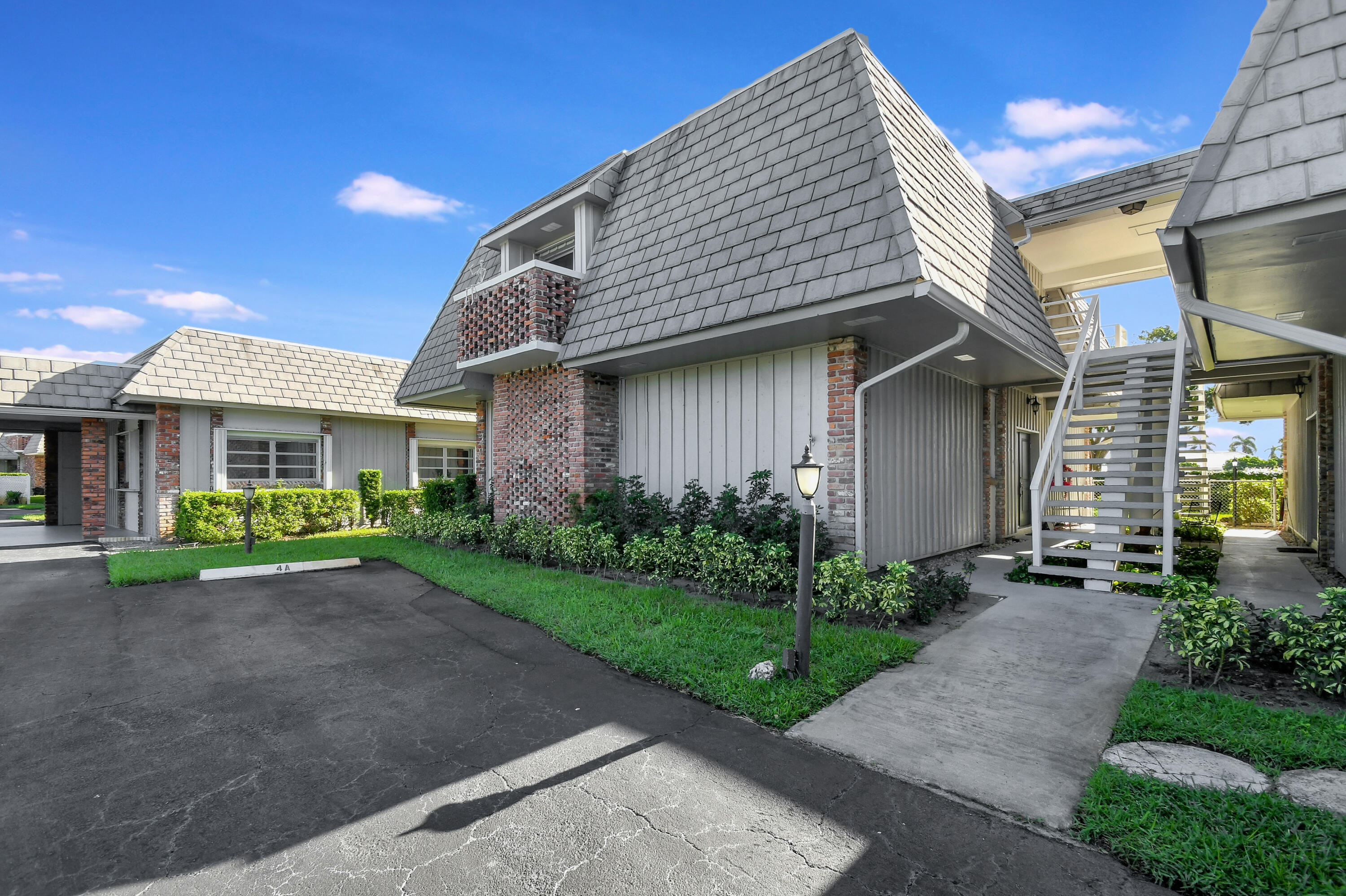 a front view of a house with a garden and plants