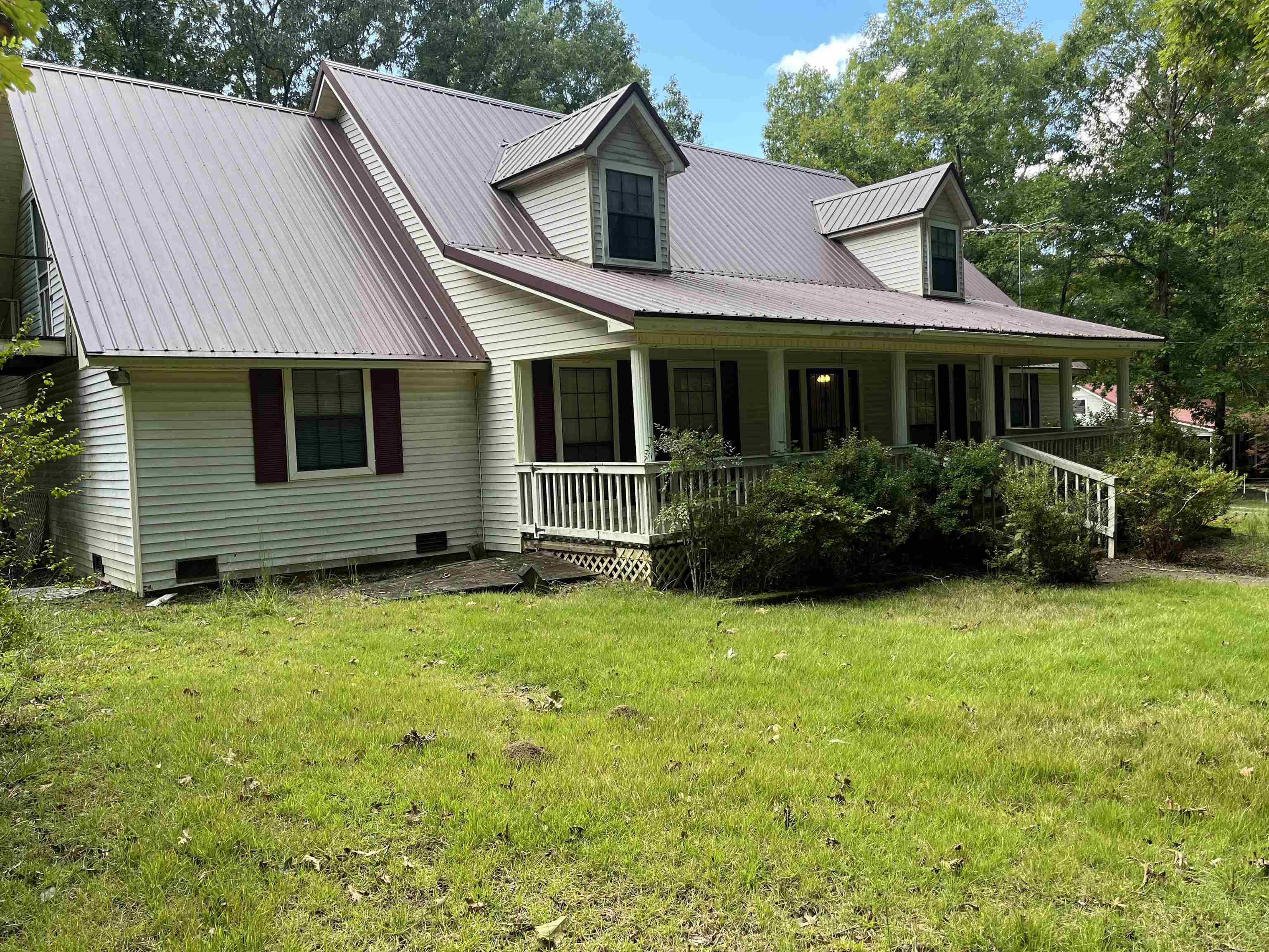 New england style home featuring a front lawn and covered porch