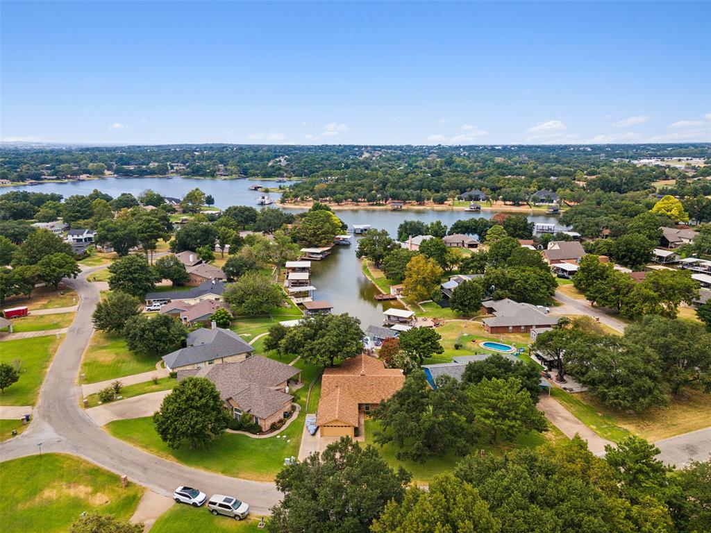 an aerial view of residential houses with outdoor space and trees