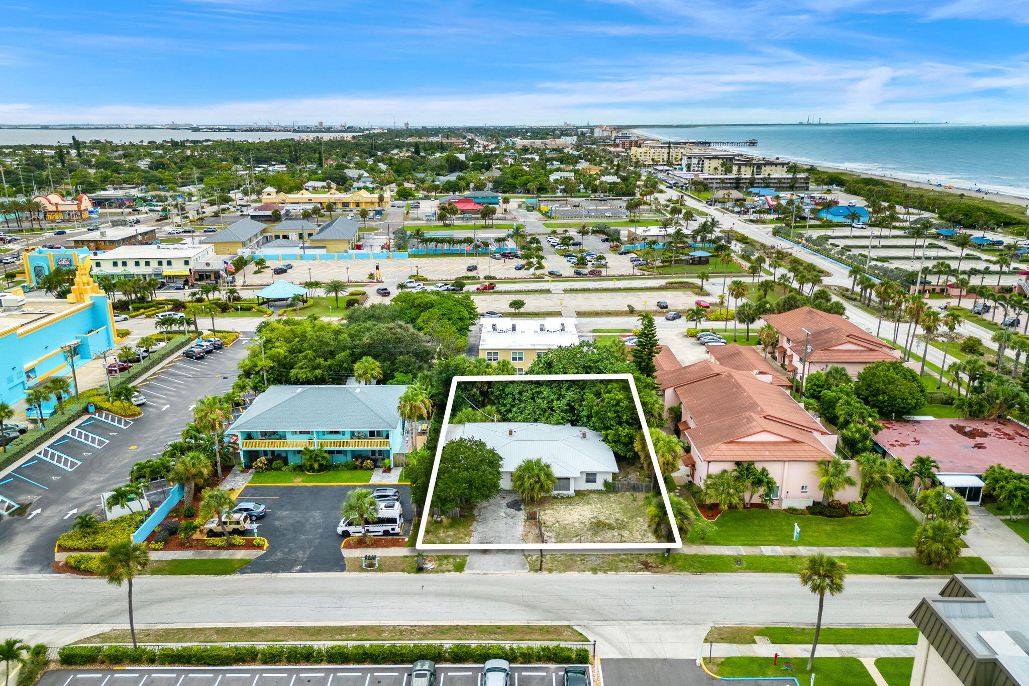 an aerial view of residential houses with outdoor space and ocean view