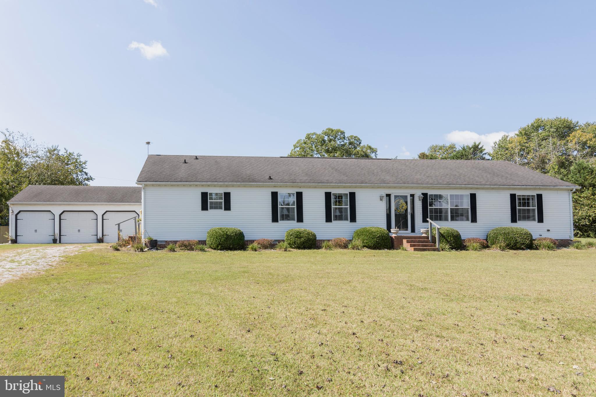 a front view of a house with a yard and trees