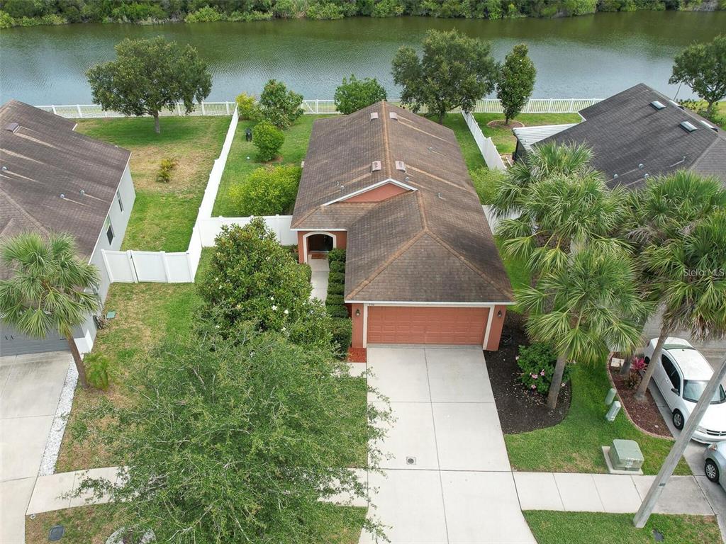 a view of a lake with a yard and large trees