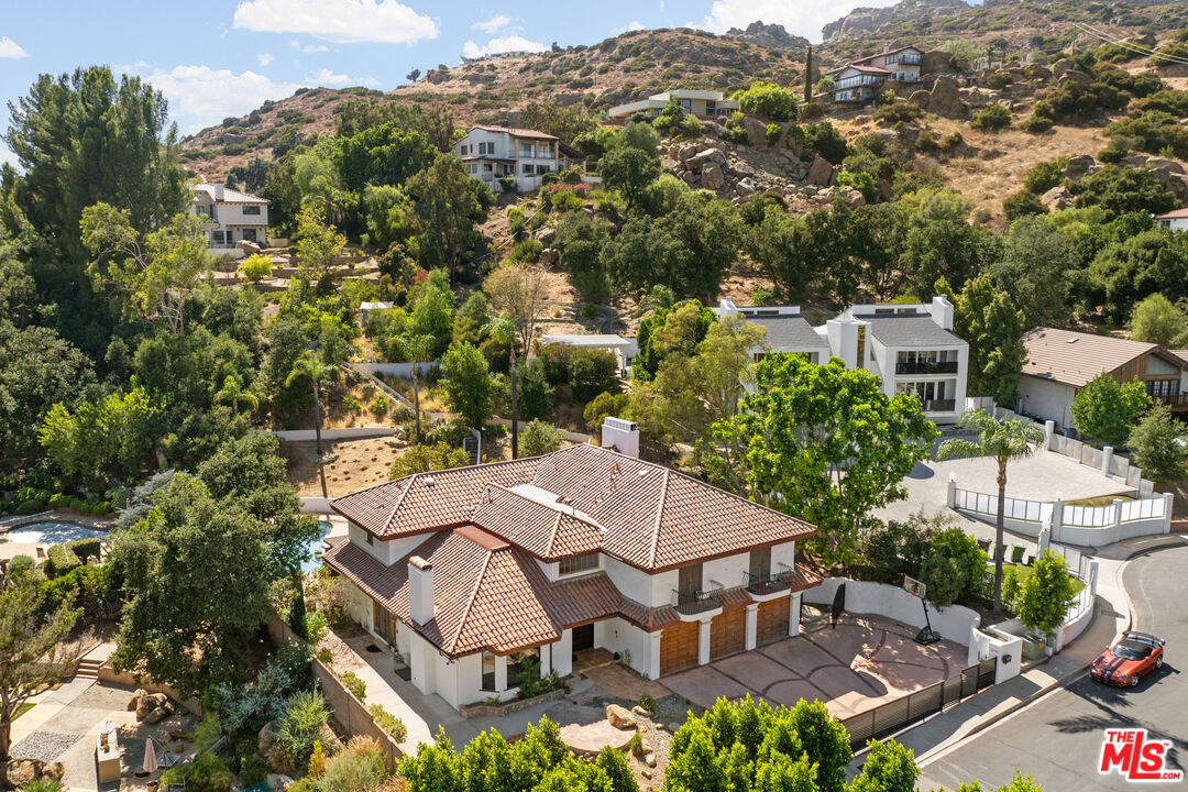 an aerial view of a house with swimming pool and mountain view