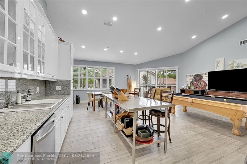 a large dining hall with stainless steel appliances granite countertop a stove and a view of living room