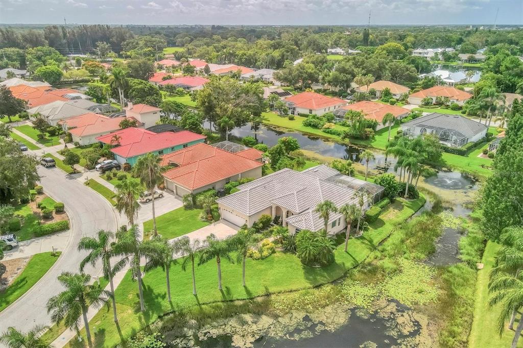 an aerial view of residential houses with outdoor space and trees