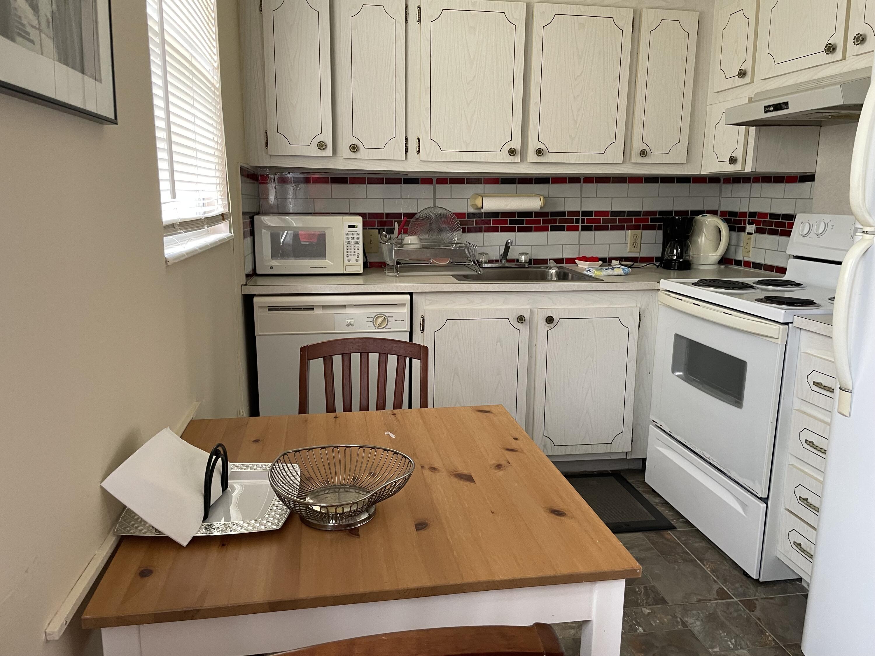 a kitchen with white cabinets and appliances