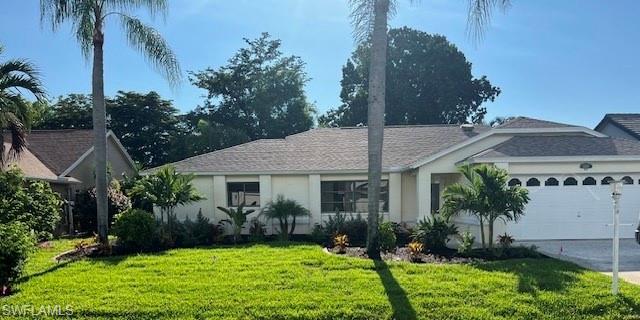 a front view of a house with a yard and potted plants