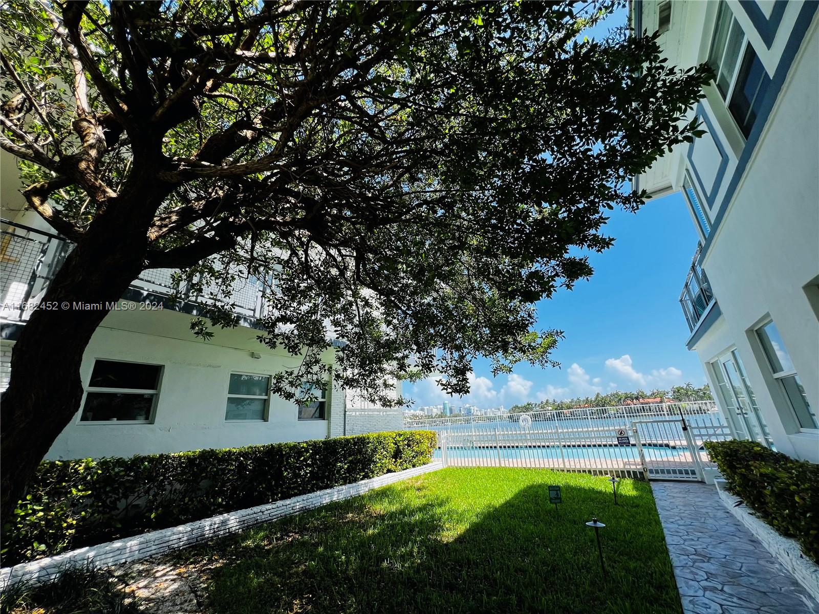 a view of yard with swimming pool and green space