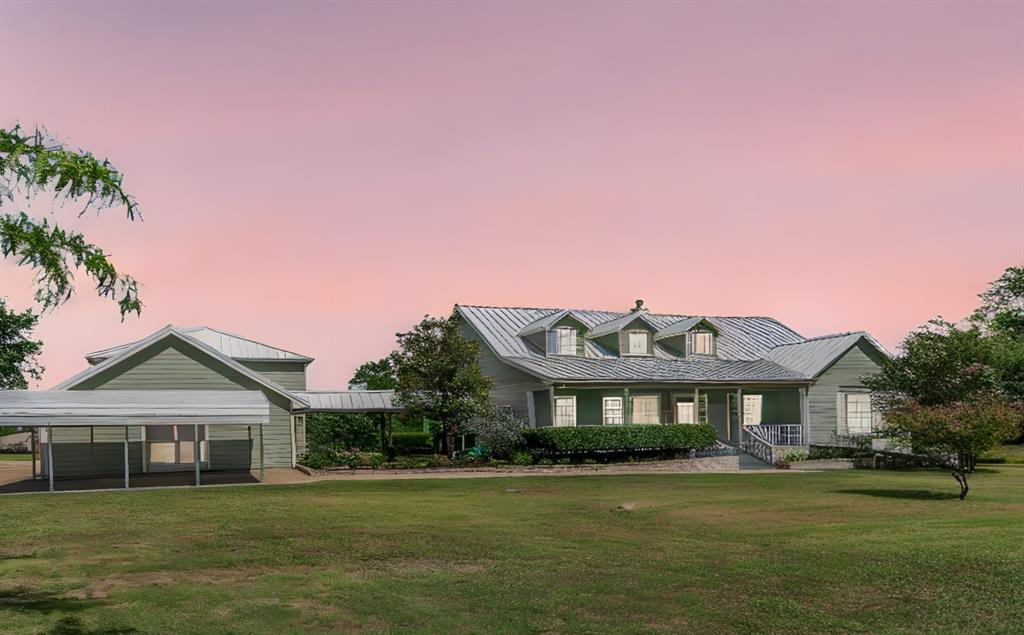 a front view of a house with a garden and lake view