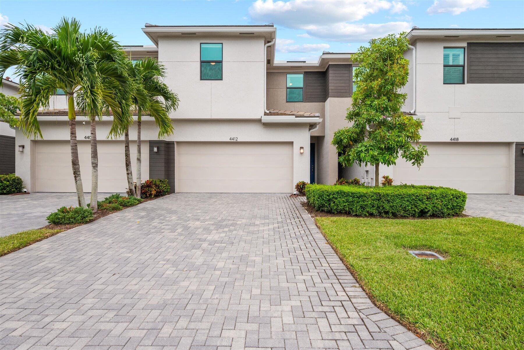 a front view of a house with a yard and a garage