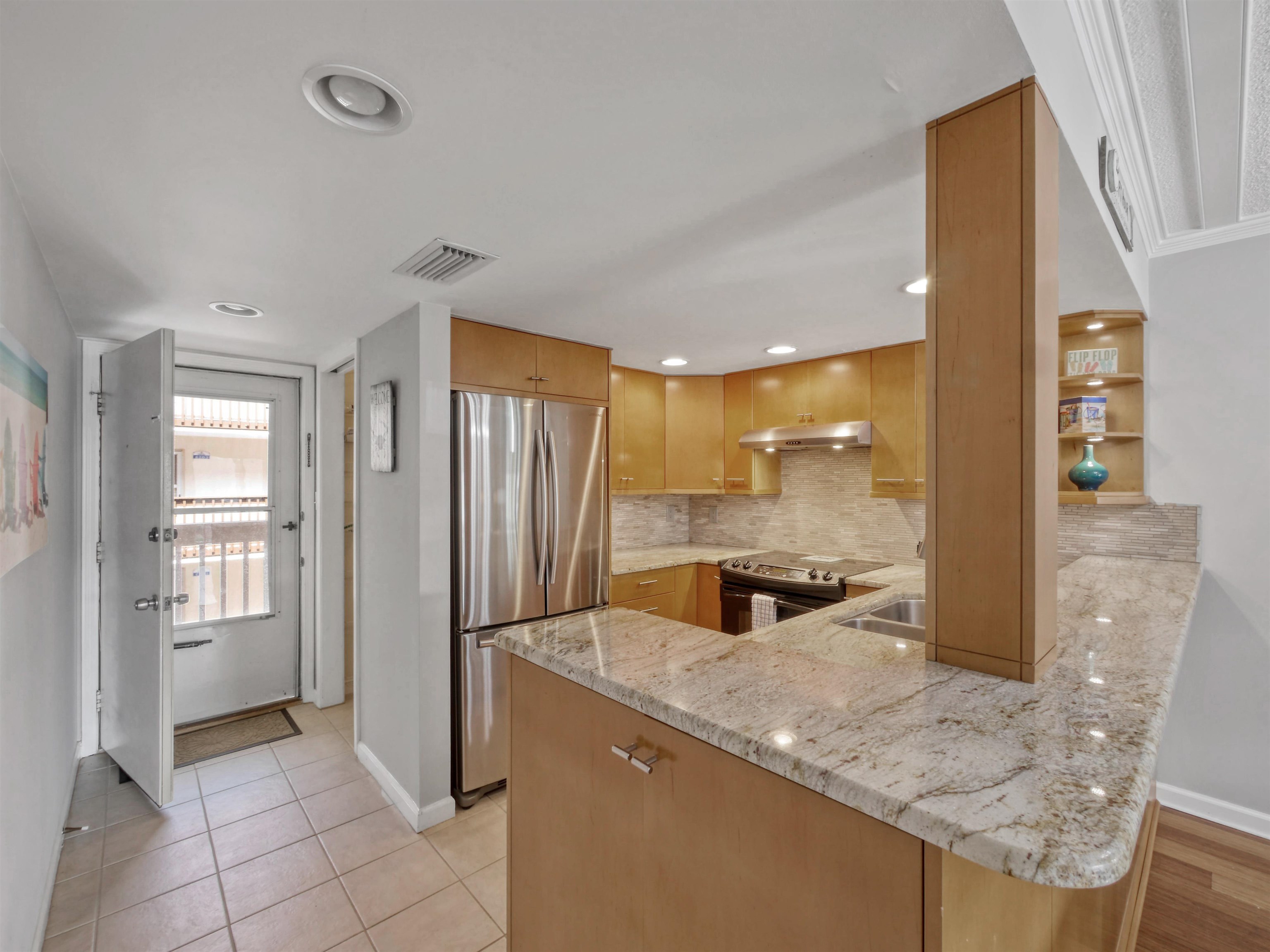 a kitchen with stainless steel appliances granite countertop a refrigerator and a sink