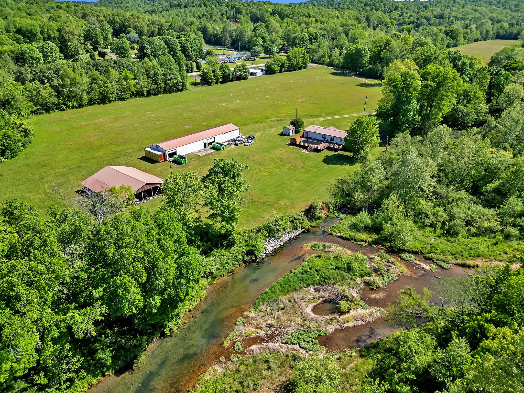 an aerial view of a residential houses with outdoor space and trees