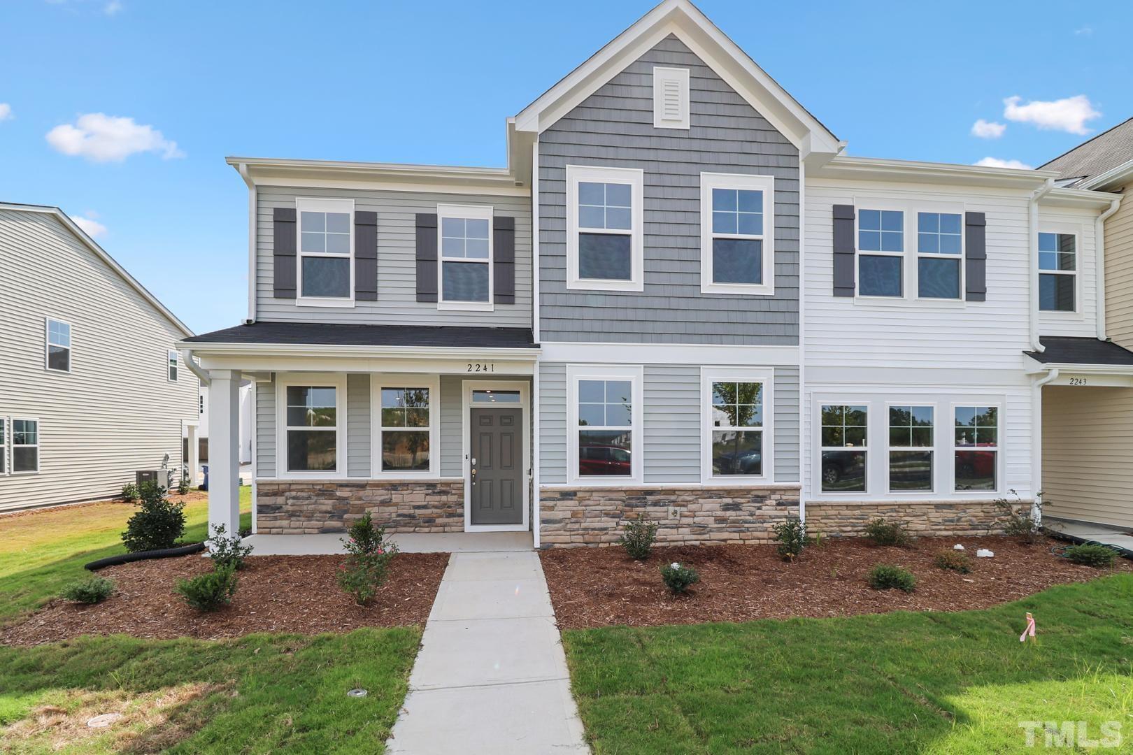 a front view of a house with a yard and outdoor seating