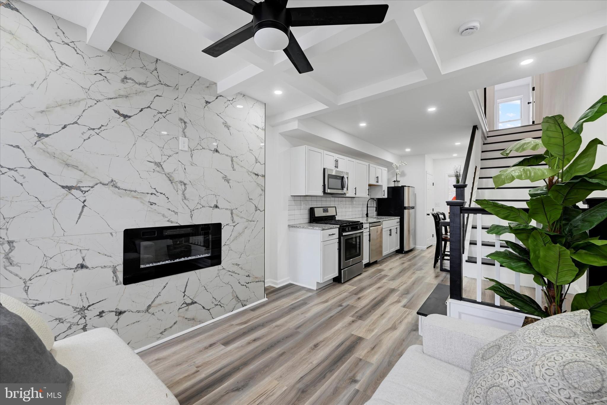 a living room with stainless steel appliances kitchen island granite countertop furniture a rug a fireplace and a counter top space