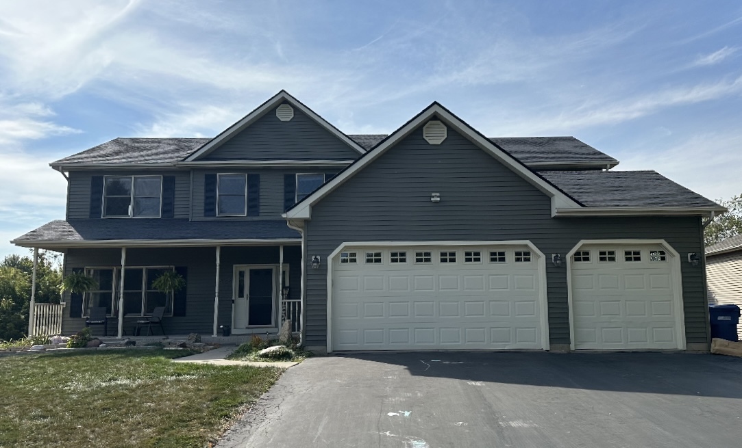 a view of a house with yard and garage