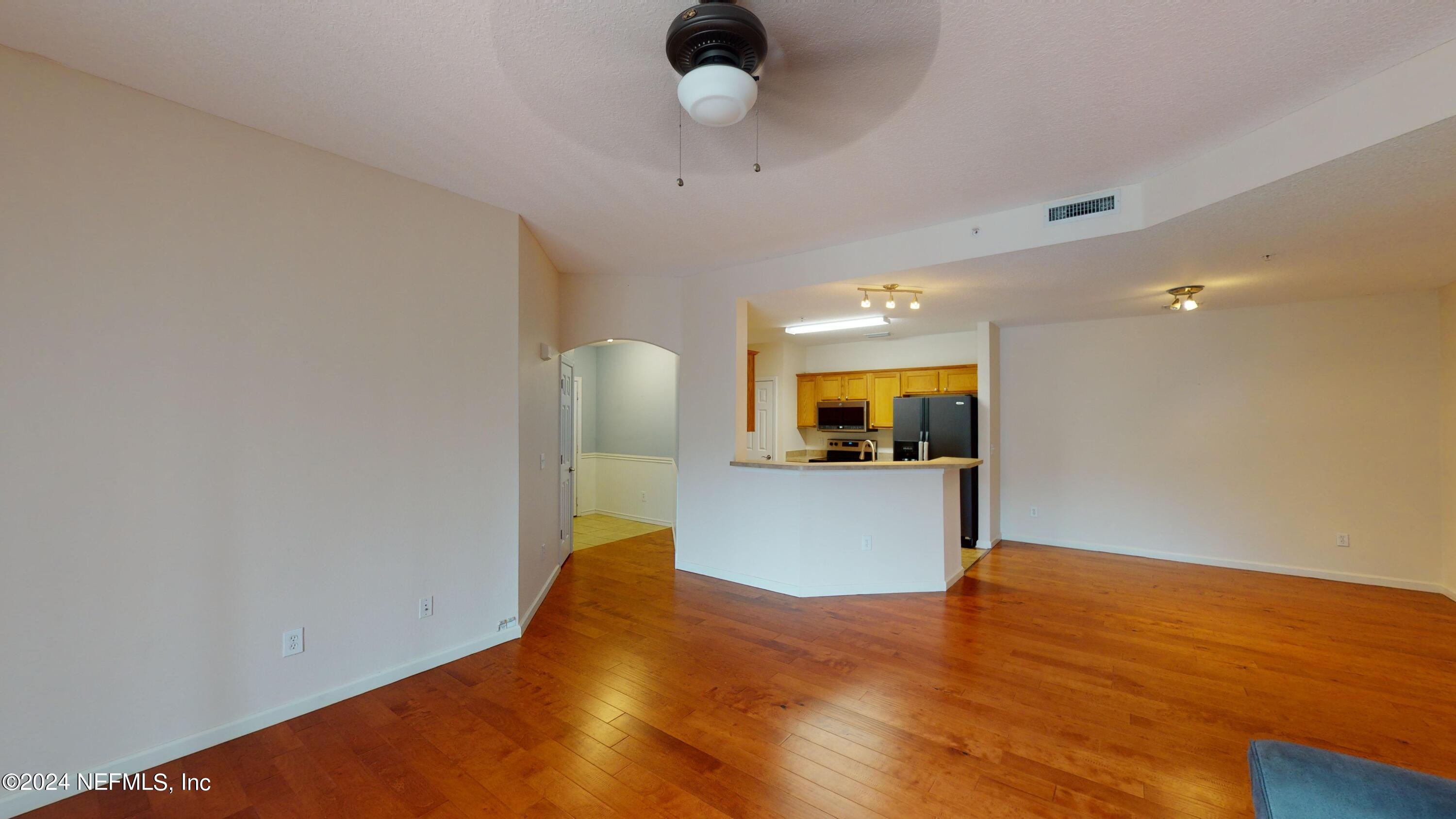 a view of a room with a dishwasher and wooden floor