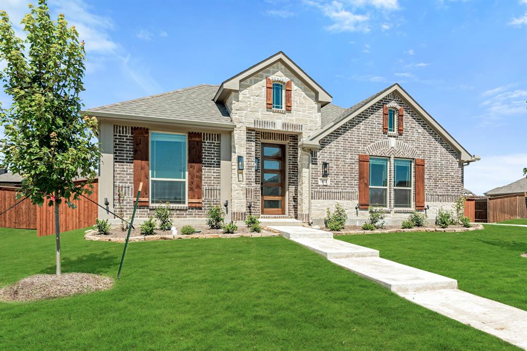 a front view of a house with a yard and trees