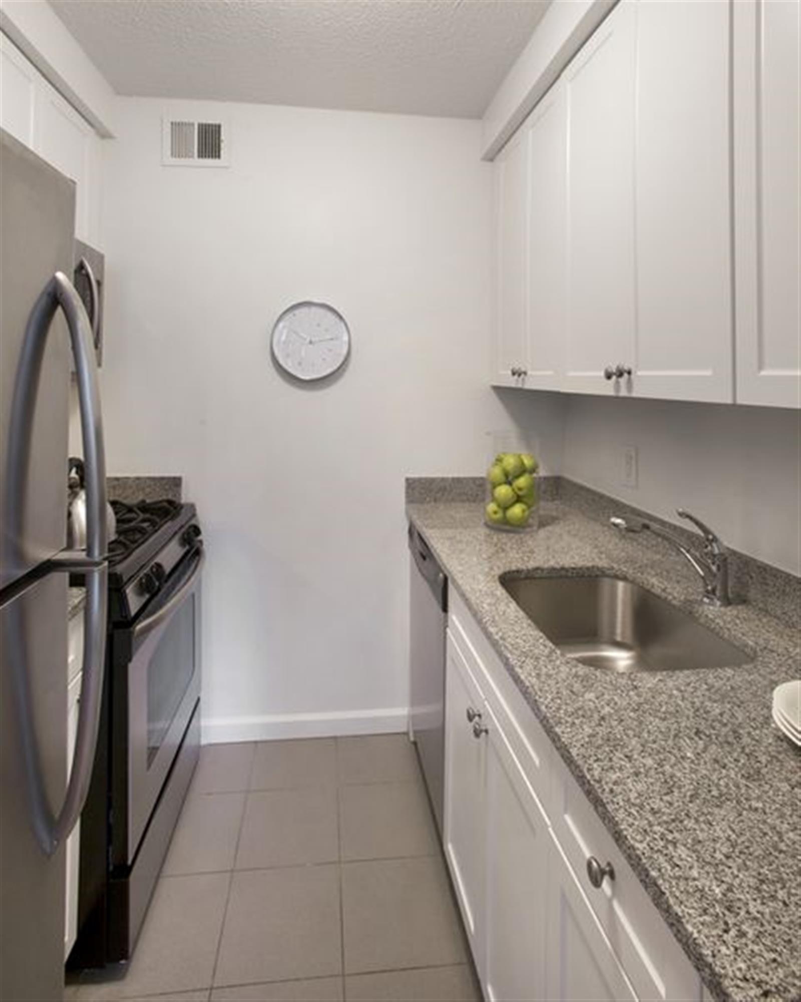 a kitchen with granite countertop a sink a stove and refrigerator