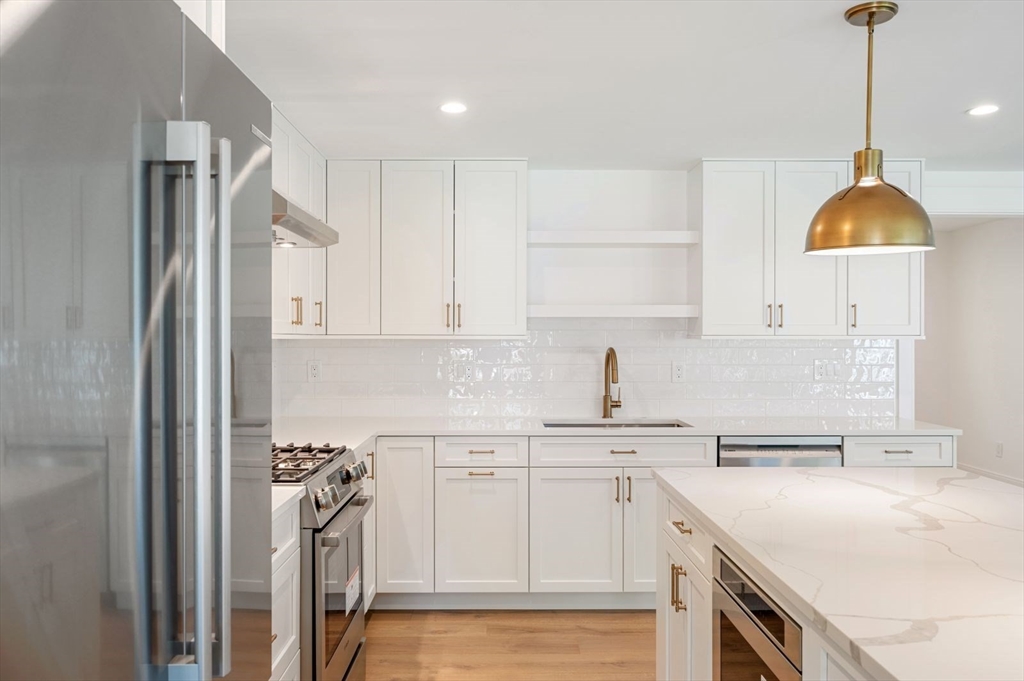 a kitchen with a sink a stove a refrigerator and cabinets