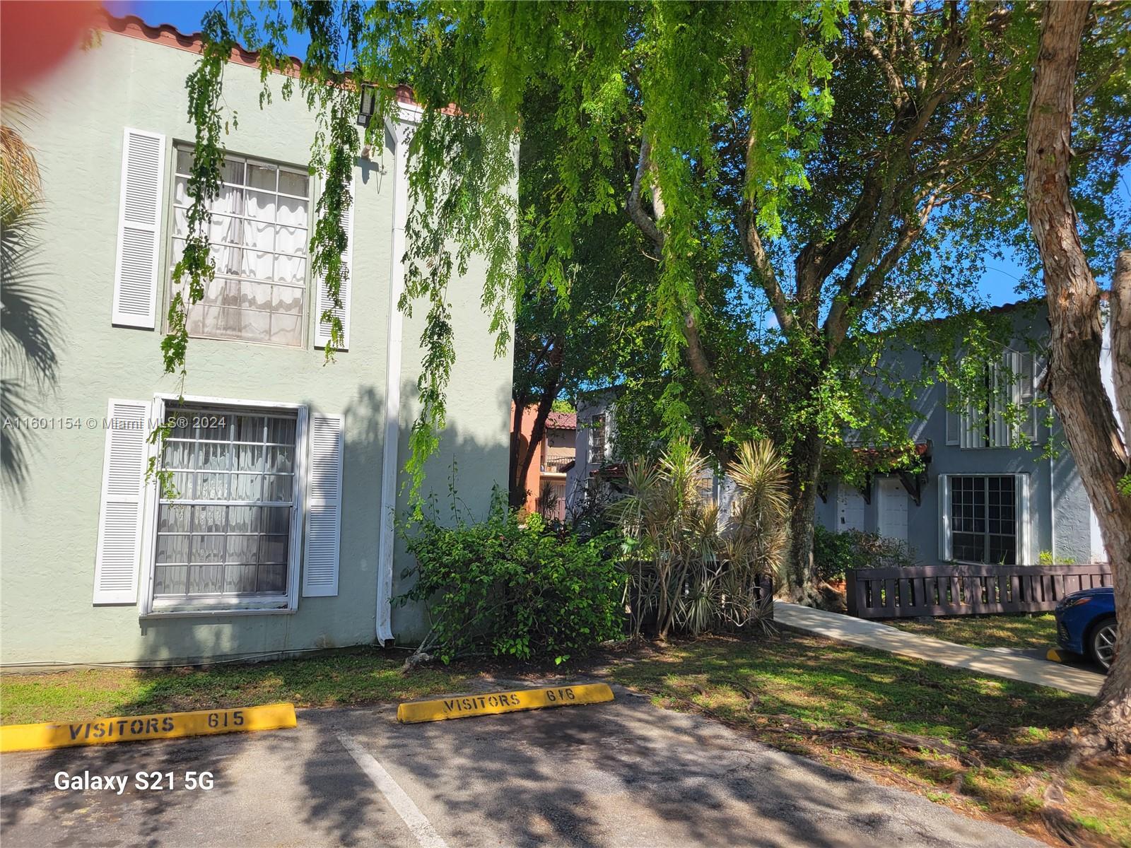 a view of a house with a large tree and a yard