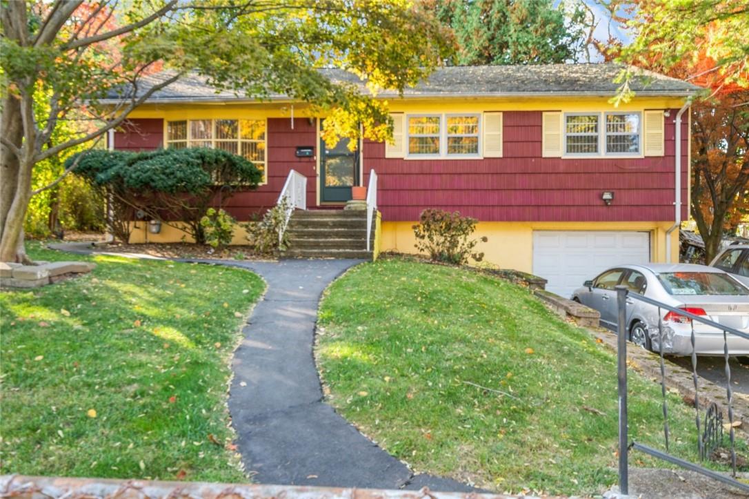 View of front of house with a front yard and a garage