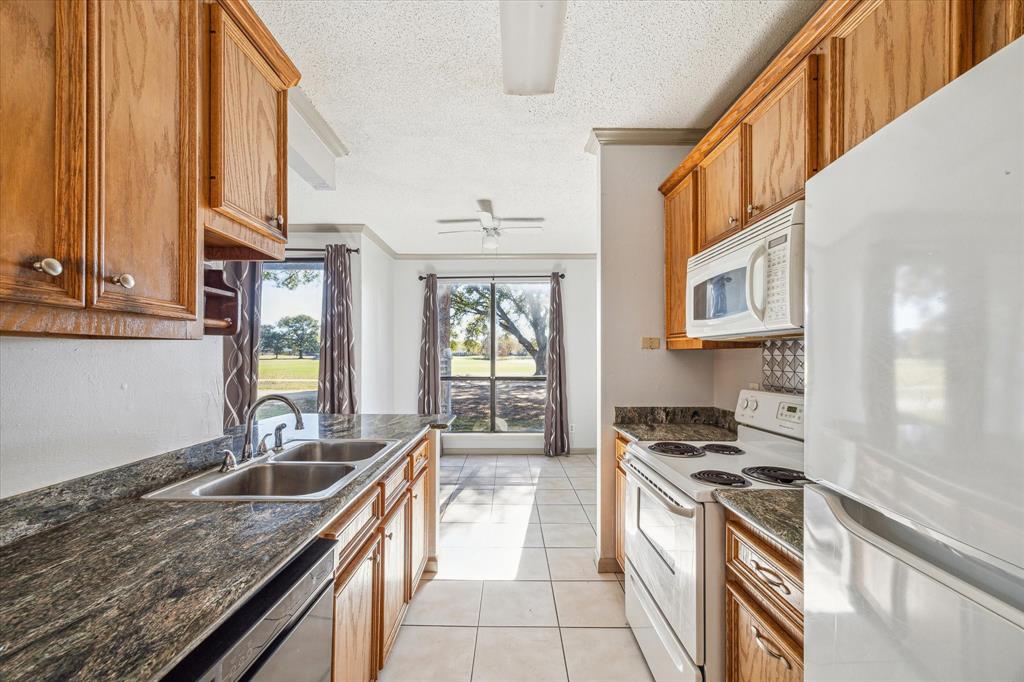 a kitchen with stainless steel appliances granite countertop a stove a sink and a refrigerator