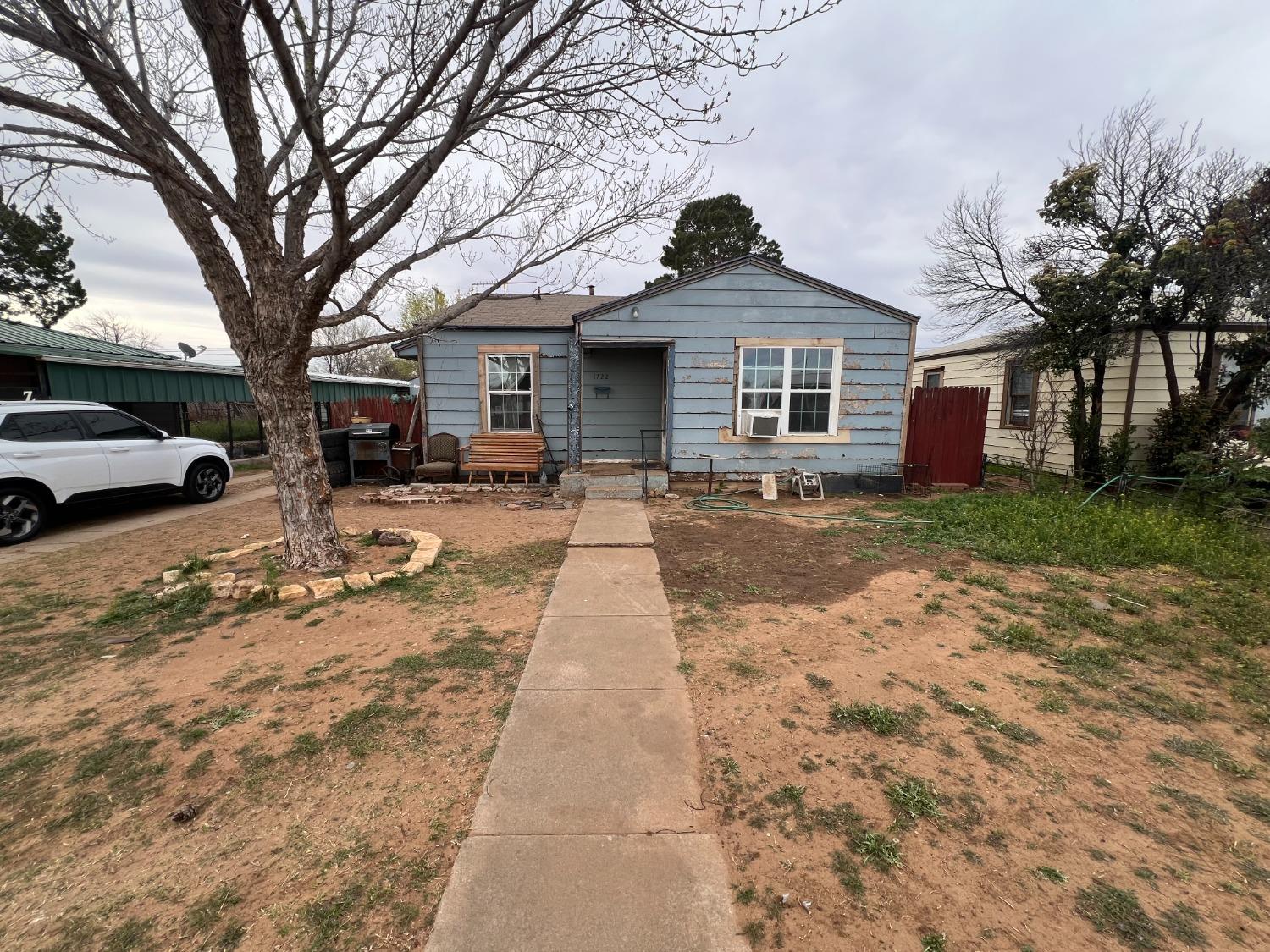 a front view of a house with yard and trees