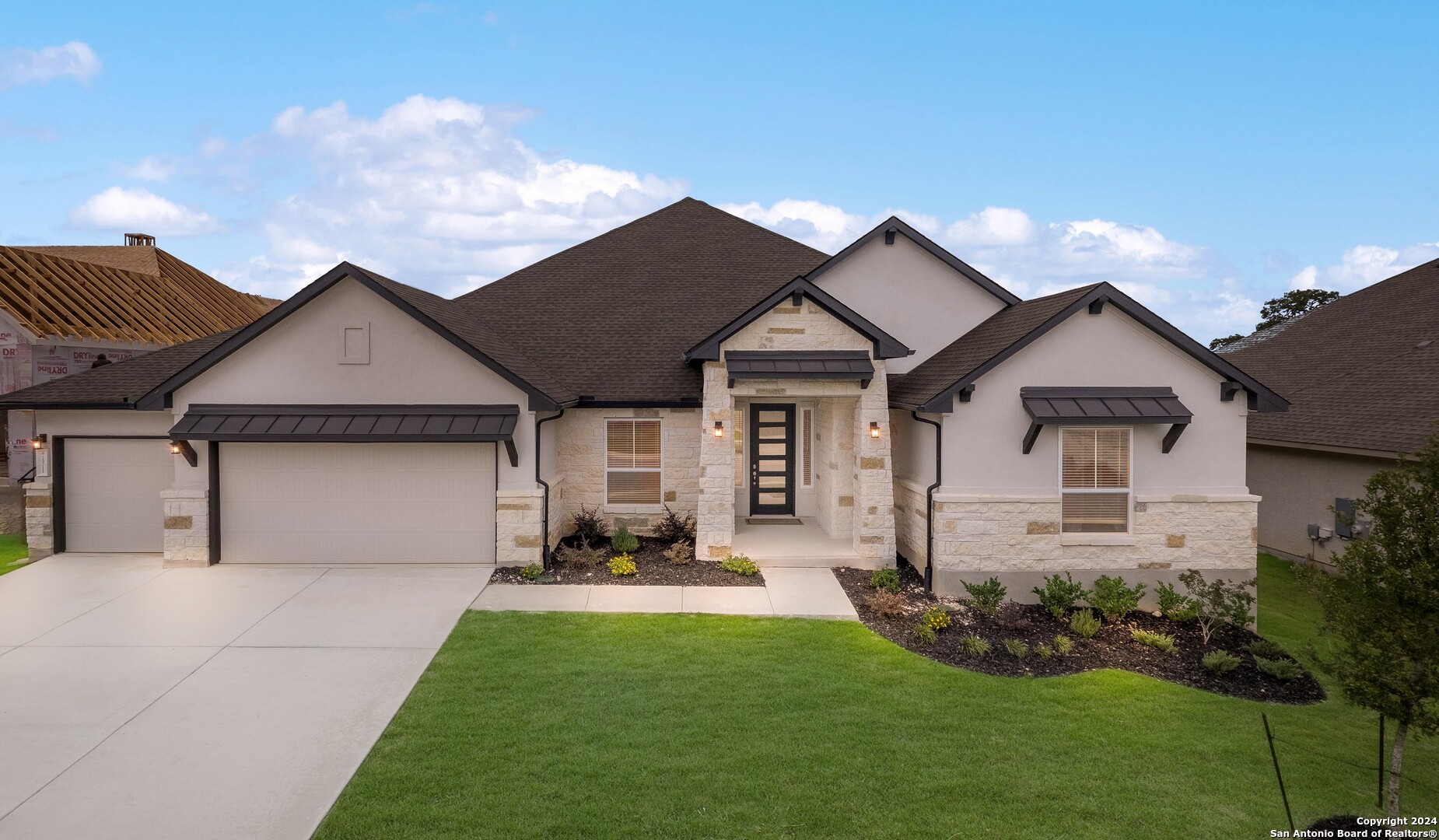 a front view of a house with a yard and garage