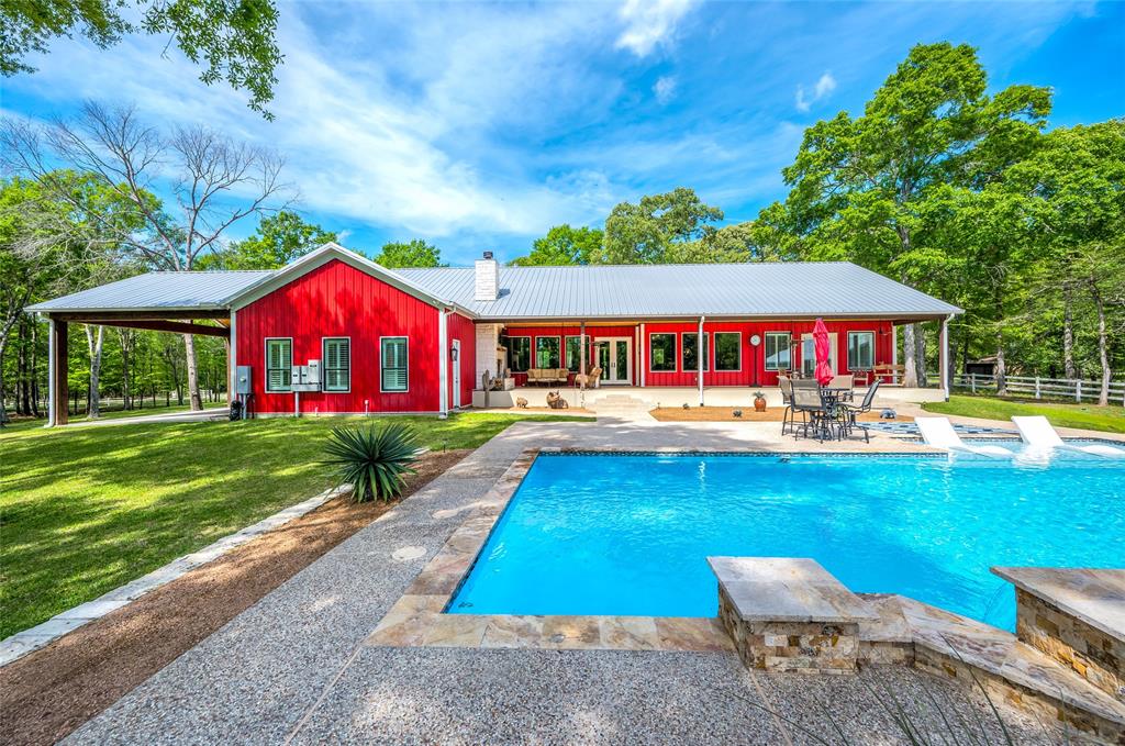 a view of swimming pool with lawn chairs and plants