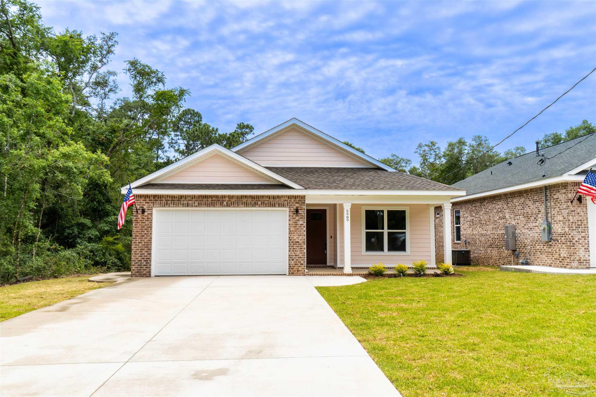 a front view of a house with a garden and yard