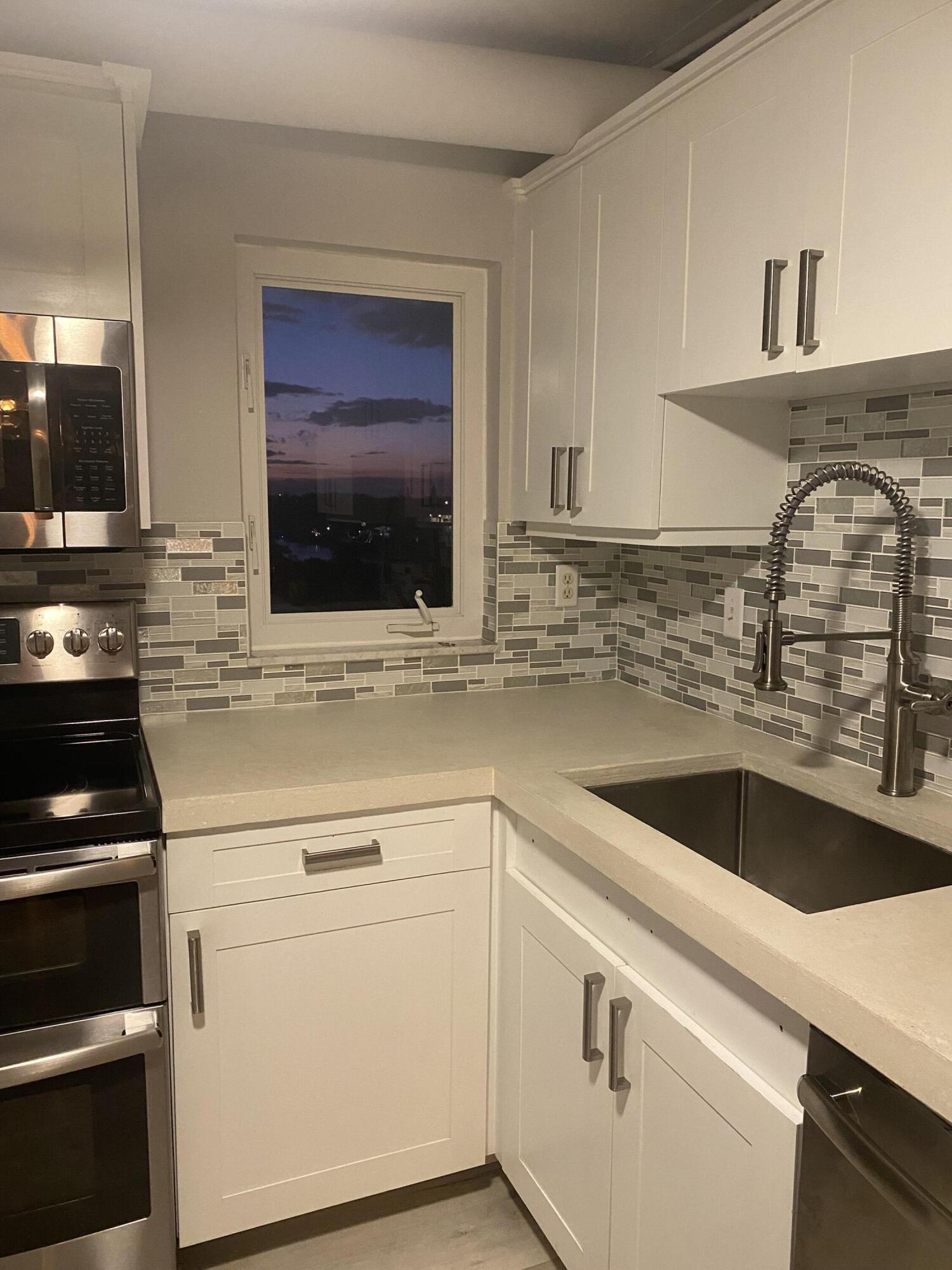 a kitchen with granite countertop white cabinets and white appliances