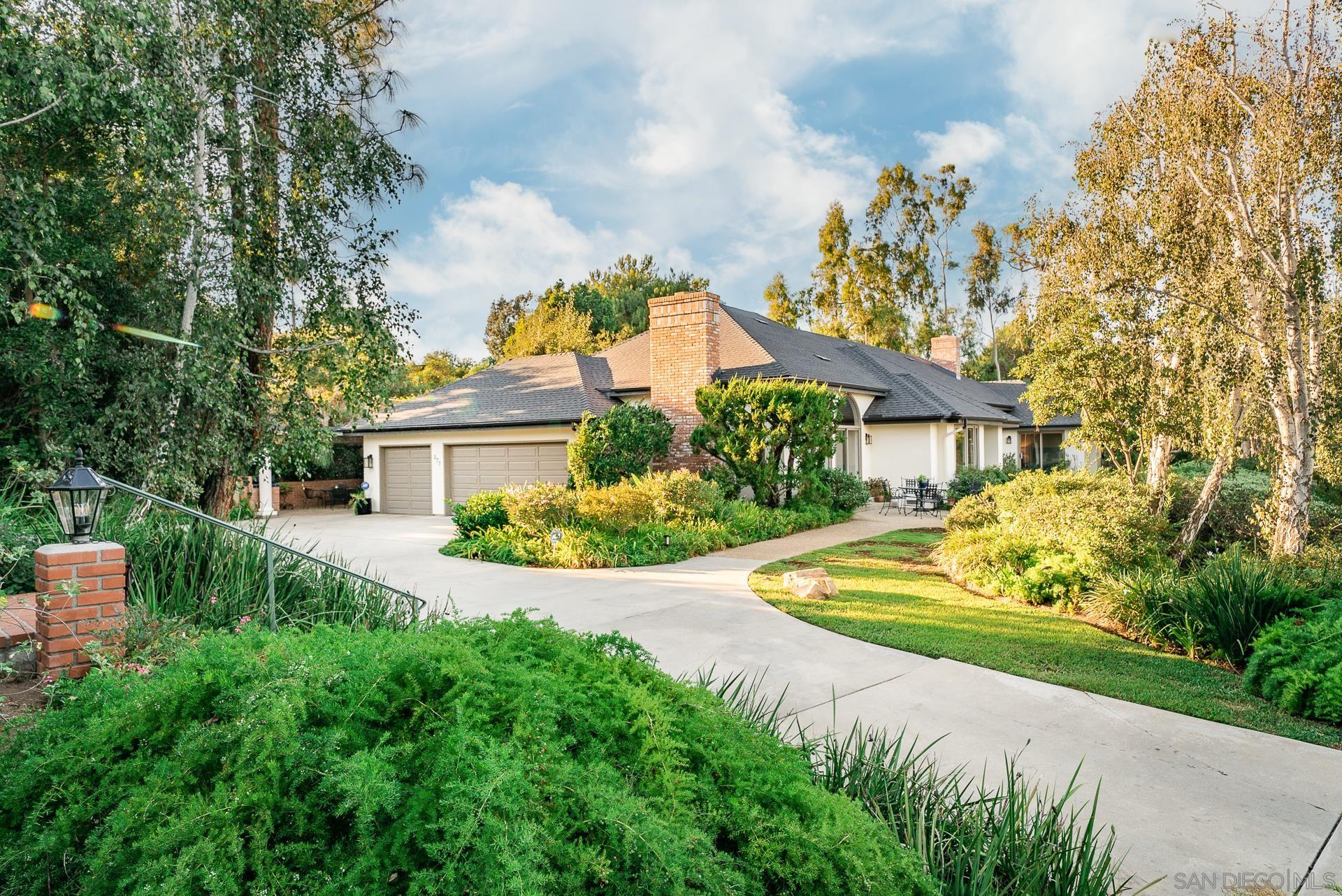 a front view of a house with a yard and fountain