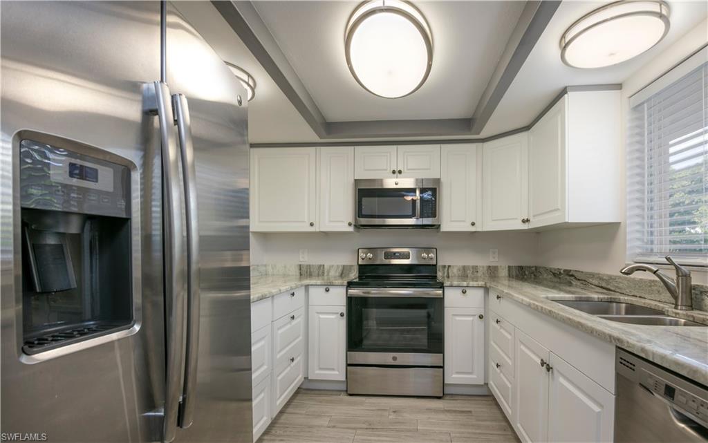 a kitchen with stainless steel appliances a stove a sink and a refrigerator