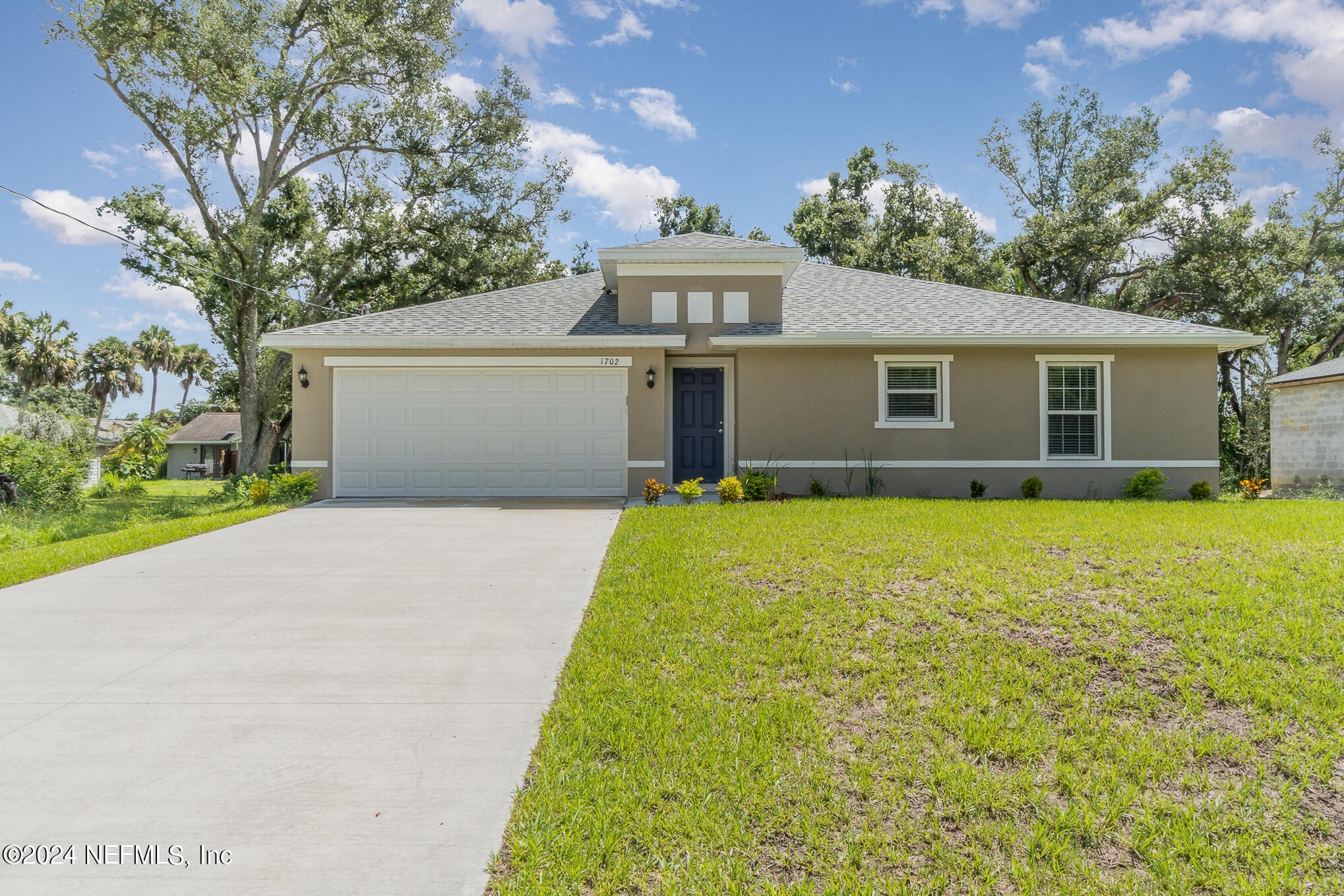 a front view of house with yard and trees