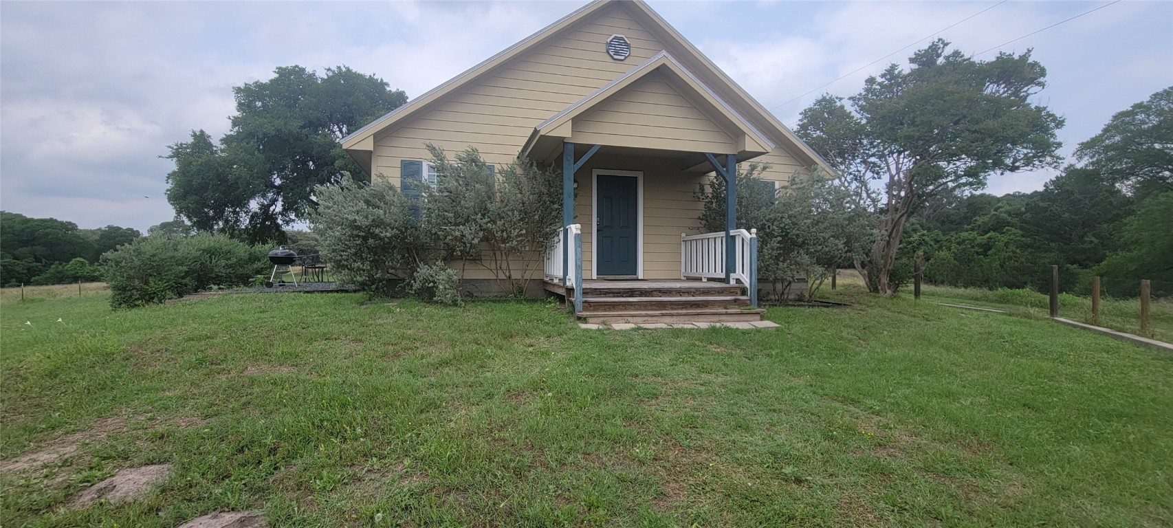 a view of backyard of house with green space