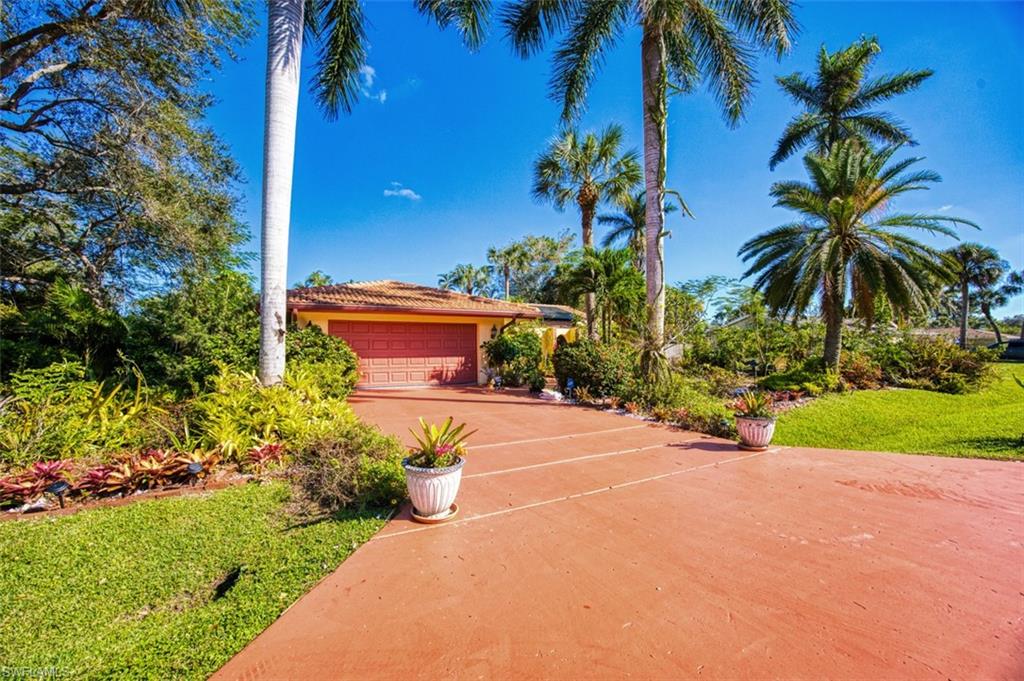 Mediterranean / spanish home with a garage and a front lawn