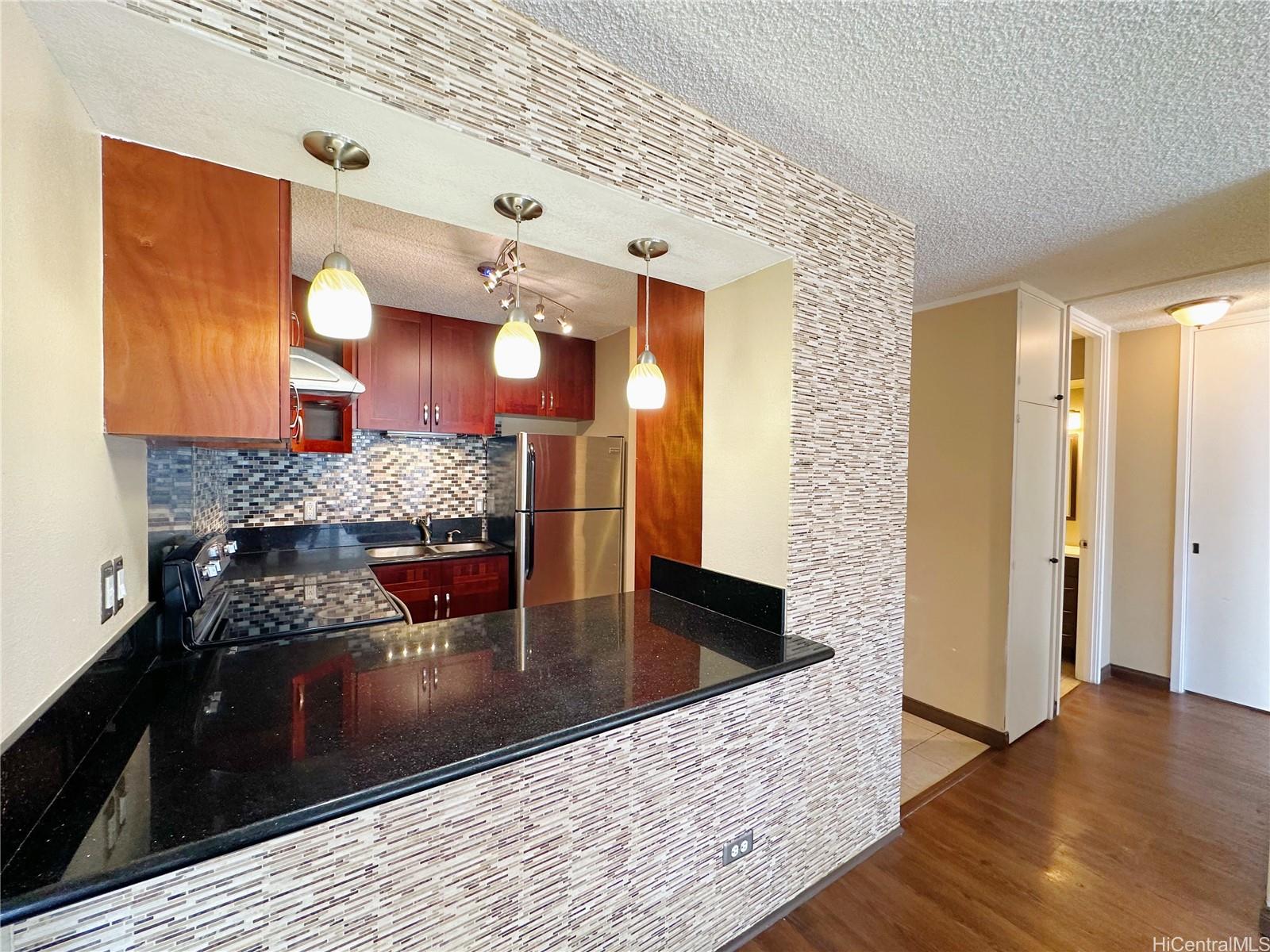 a kitchen with granite countertop a stove and cabinets