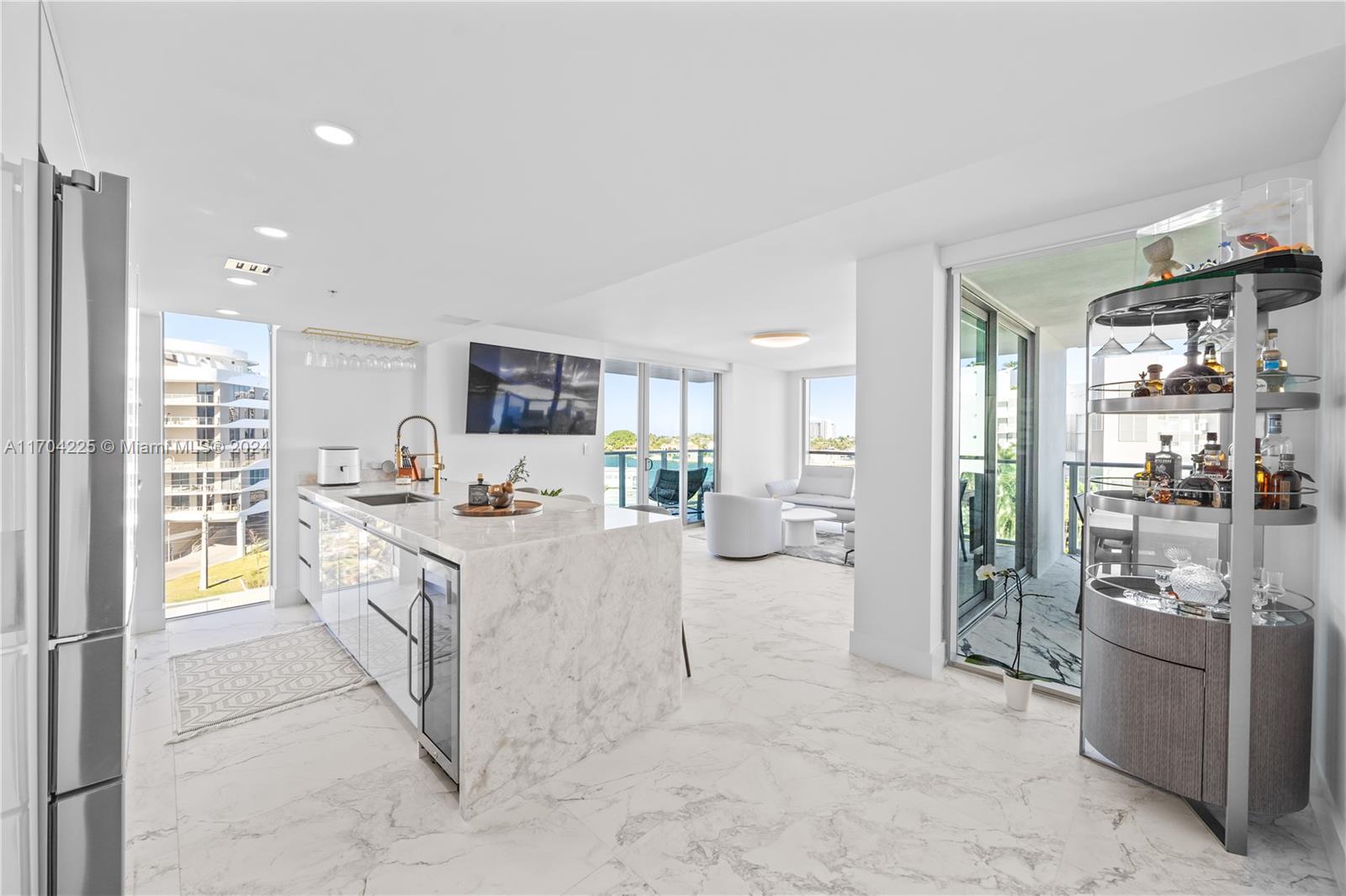 a large white kitchen with granite countertop a sink and cabinets