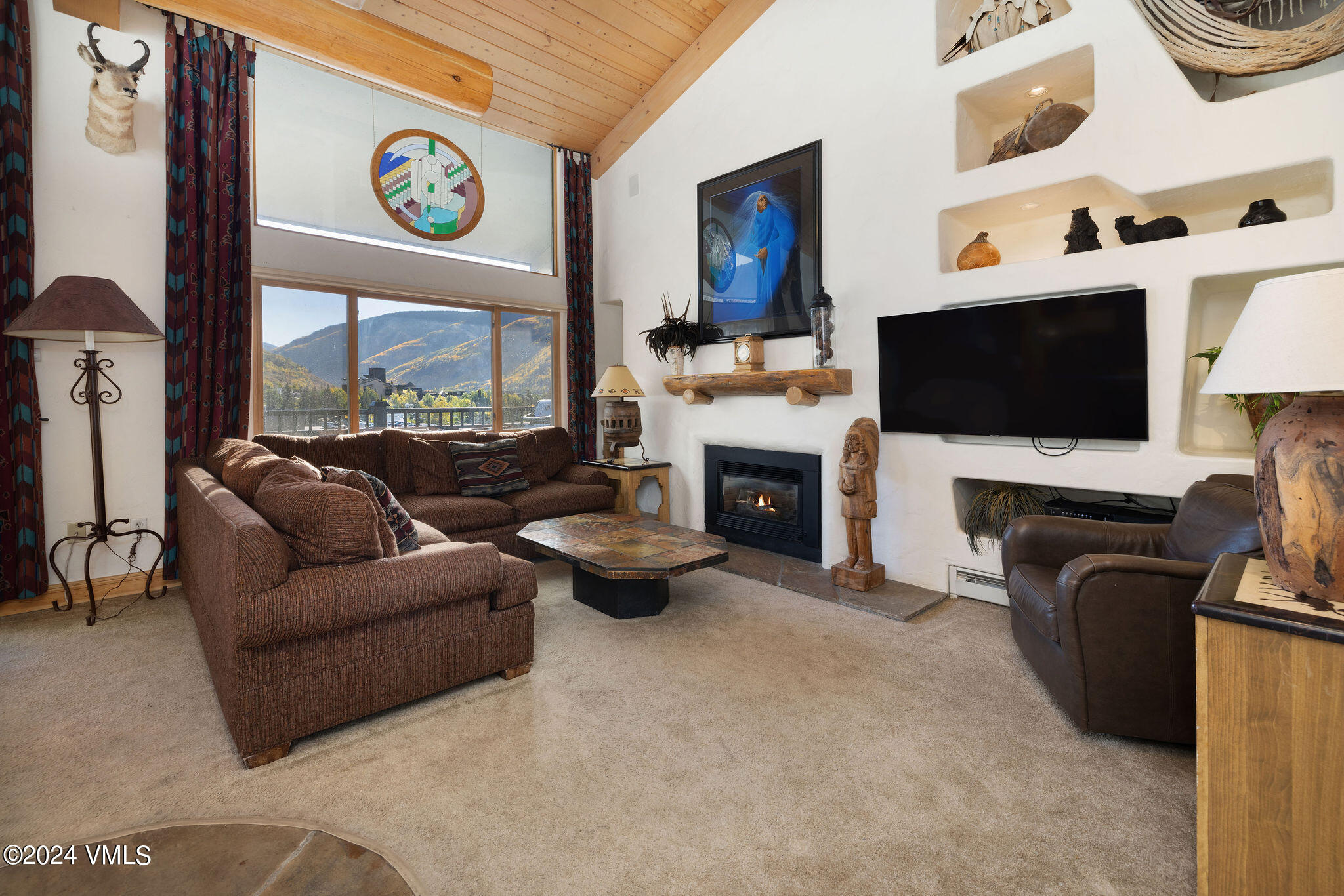 a living room with furniture a flat screen tv and a fireplace