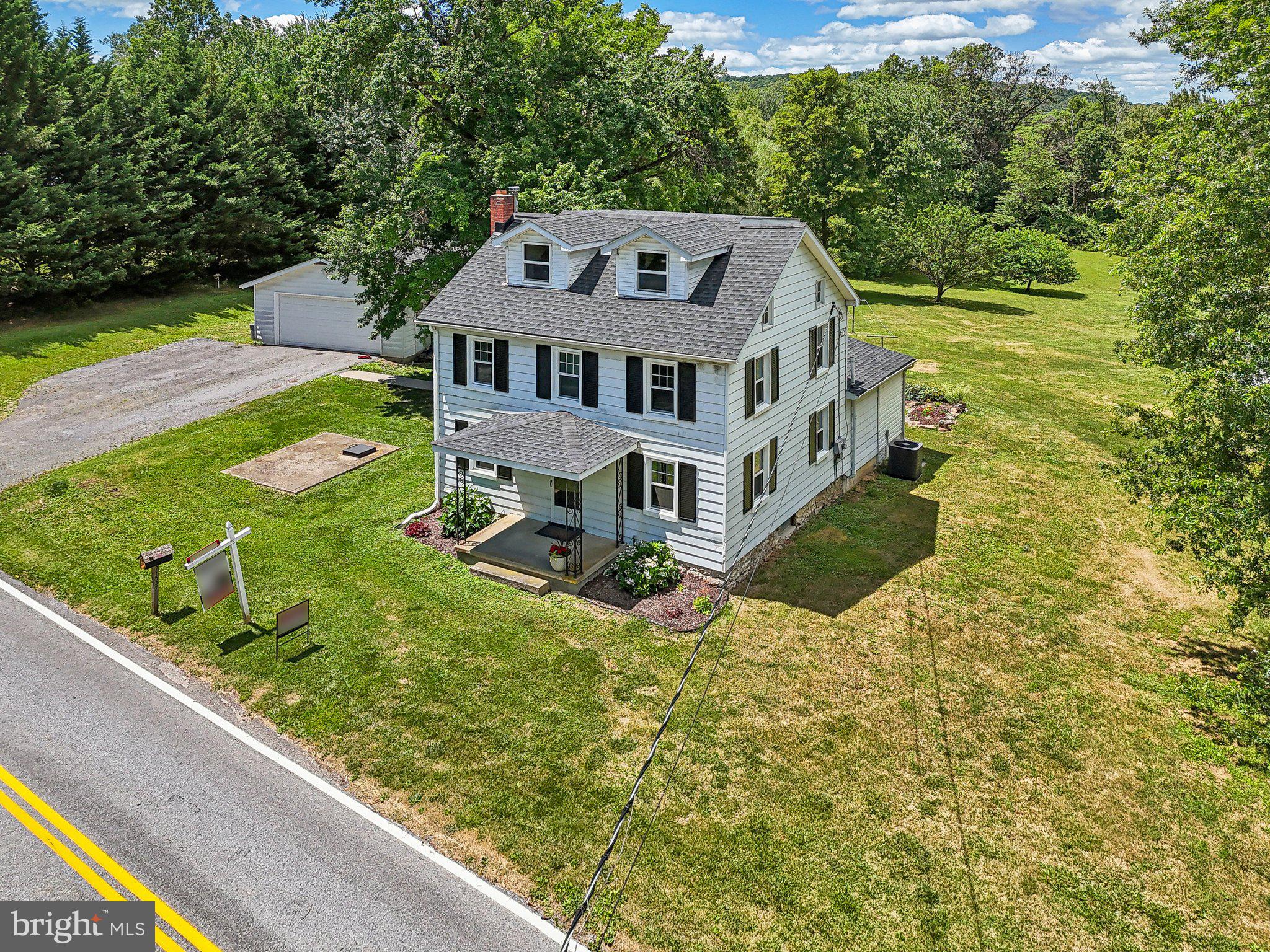 a aerial view of a house with a big yard and large trees