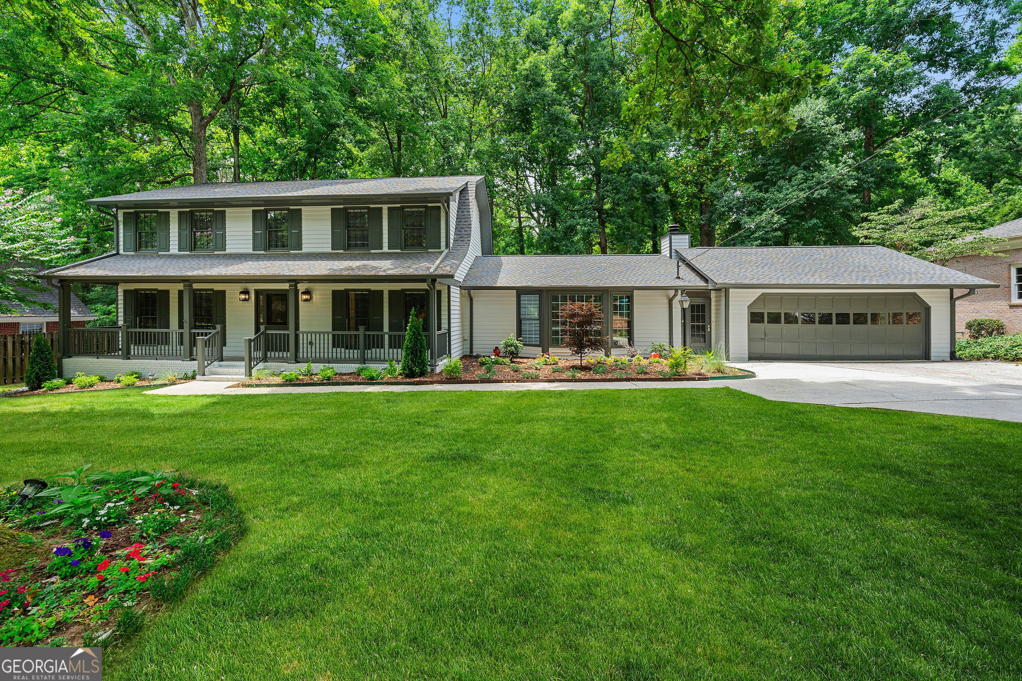 a front view of a house with yard and green space