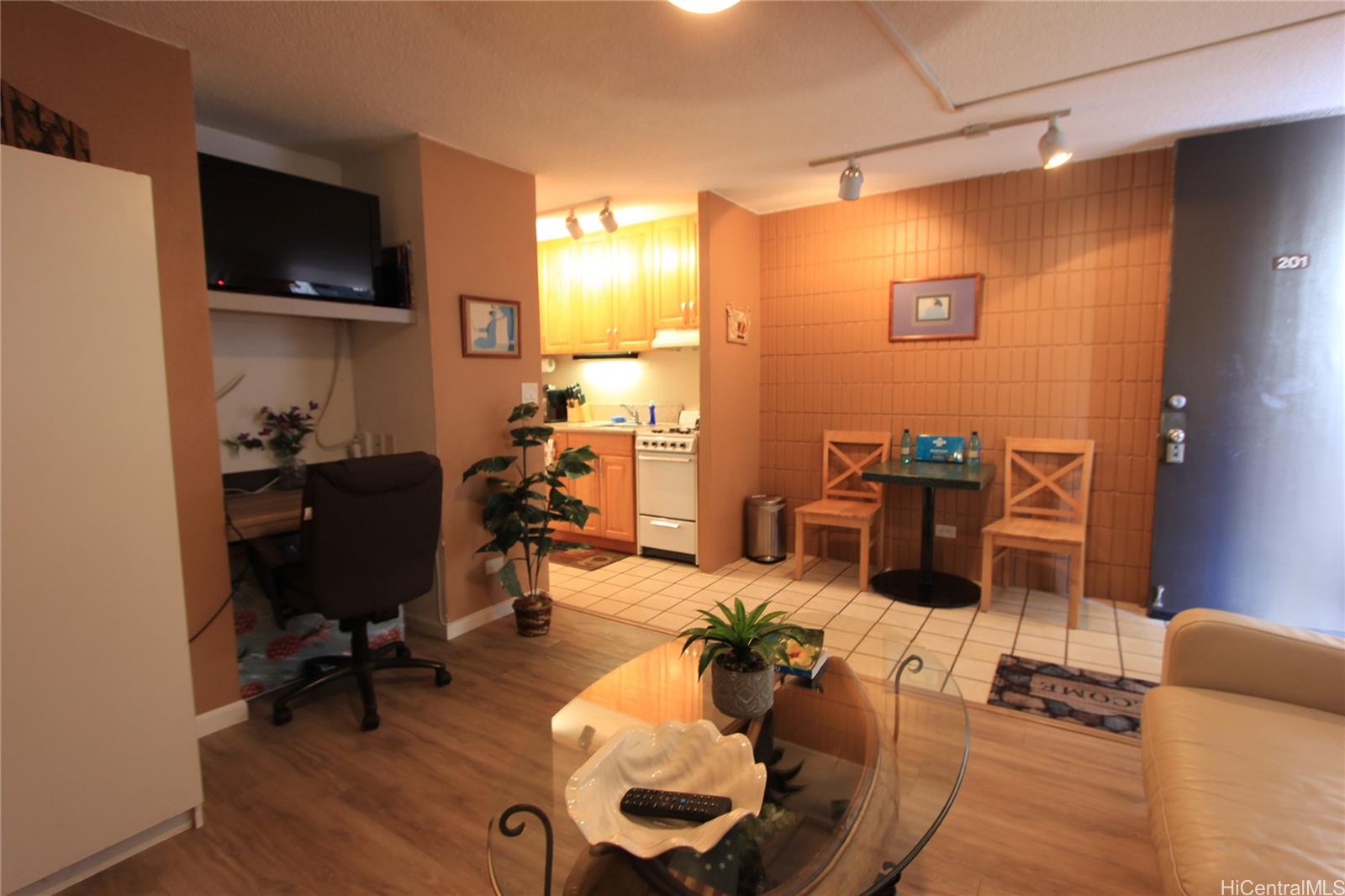 a gym room with furniture and a flat screen tv